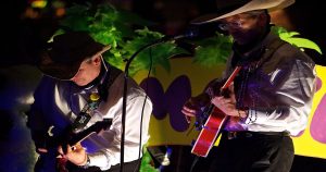 Two men performing om stage with guitars. | Fiesta in San Antonio, TX
