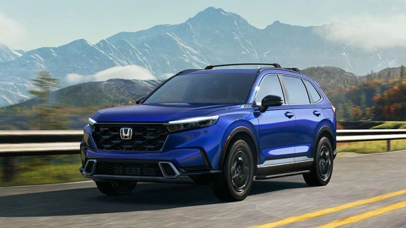 Dark Blue 2023 Honda CR-V driving on a road in the moutain area